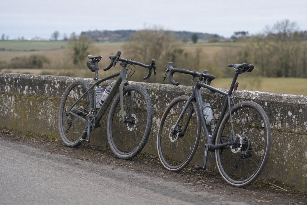 A gravel bike and a road bike parked side by side, showing the difference in tire width